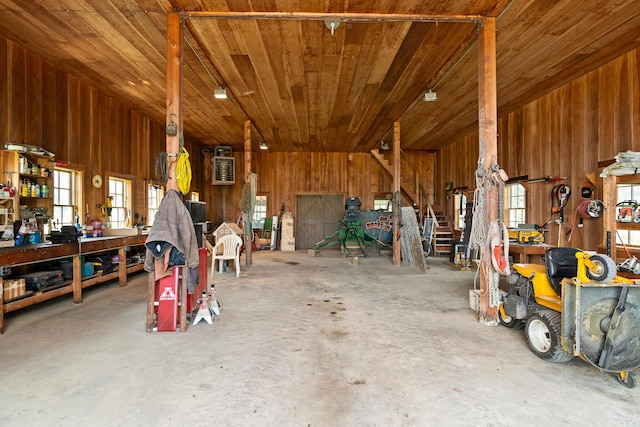 651 N Shore Rd, North Haven, ME 04853 - misc room with unfinished concrete flooring, a workshop area, wood ceiling, wood walls, and a garage