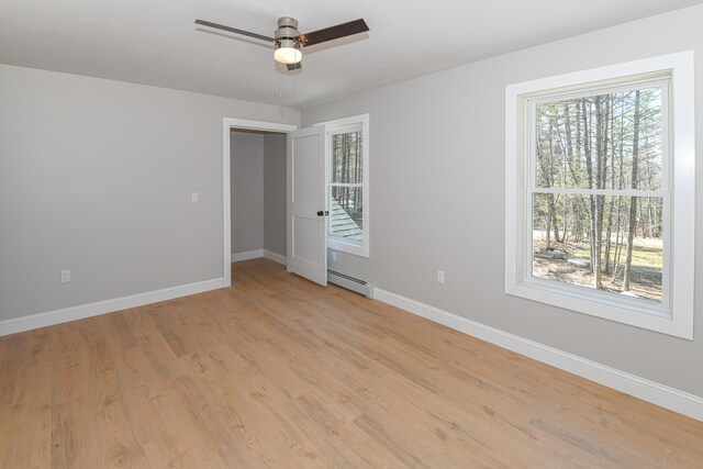 32 Rockwood Dr, Harrison, ME 04040 - spare room featuring a baseboard radiator, baseboards, plenty of natural light, and light wood finished floors