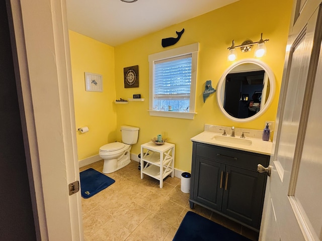 bathroom featuring vanity, tile patterned flooring, baseboards, and toilet