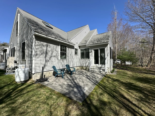 rear view of house with a patio, a shingled roof, a yard, and entry steps
