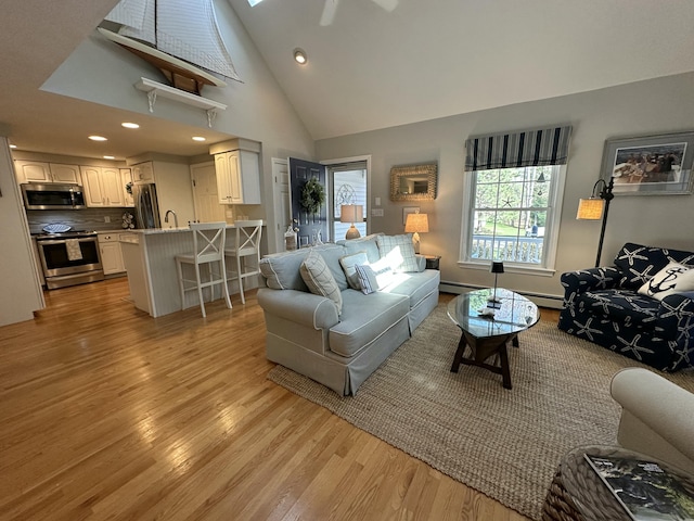 living area featuring recessed lighting, a skylight, a baseboard heating unit, and light wood-style flooring