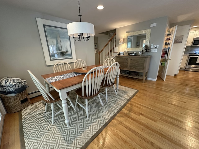 dining area featuring an inviting chandelier, stairway, baseboards, light wood-style floors, and recessed lighting
