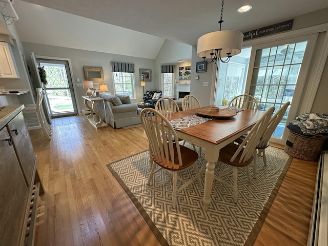 dining area featuring recessed lighting, vaulted ceiling, a chandelier, and light wood finished floors