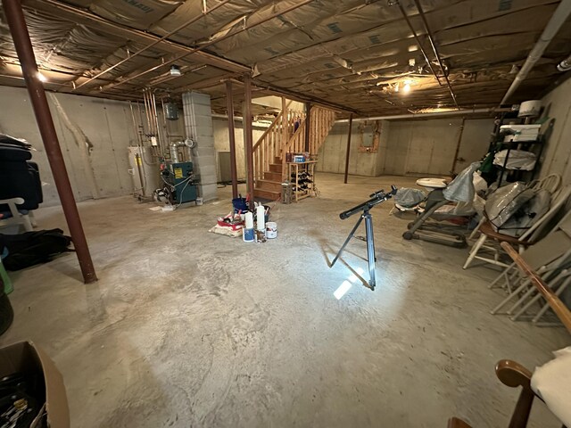 unfinished below grade area featuring a heating unit, stairs, and gas water heater