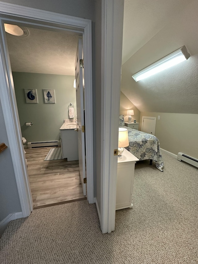 interior space with baseboards, baseboard heating, vanity, and a textured ceiling