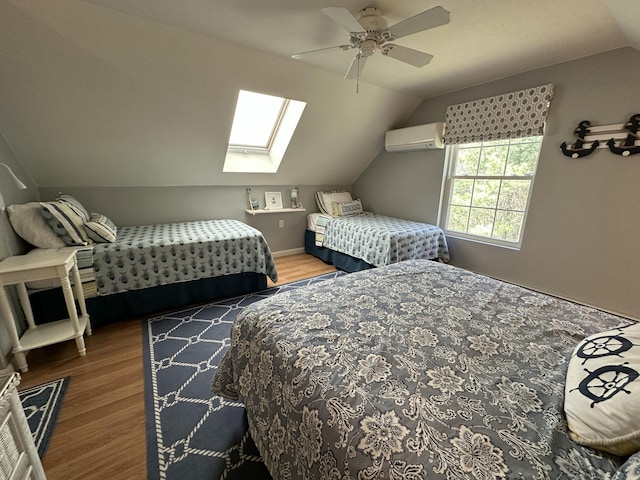 bedroom featuring an AC wall unit, a ceiling fan, wood finished floors, and vaulted ceiling with skylight