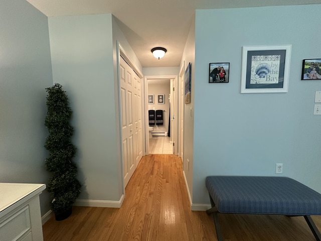 hall with baseboards and light wood-type flooring