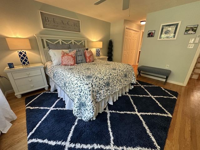 bedroom featuring baseboards, ceiling fan, a closet, and wood finished floors