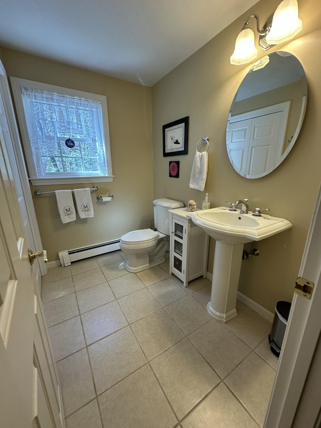 bathroom featuring baseboards, tile patterned flooring, a baseboard heating unit, and toilet