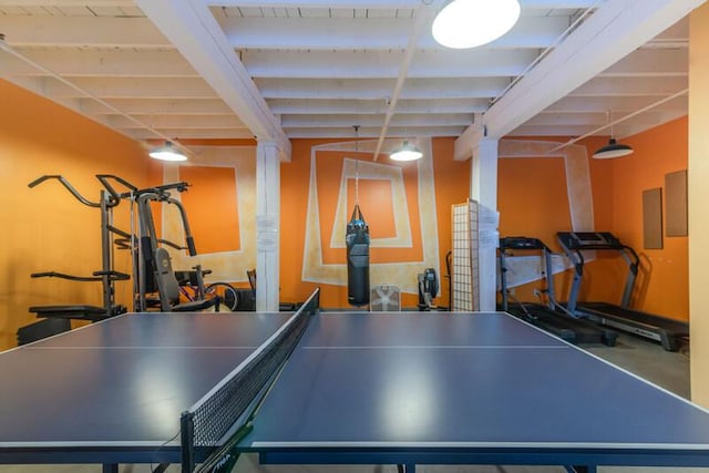rec room featuring electric panel and beamed ceiling