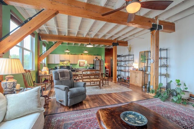 living room featuring ceiling fan, vaulted ceiling with beams, and wood finished floors