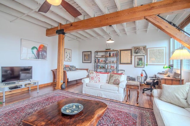 living area with lofted ceiling with beams, a ceiling fan, and wood finished floors