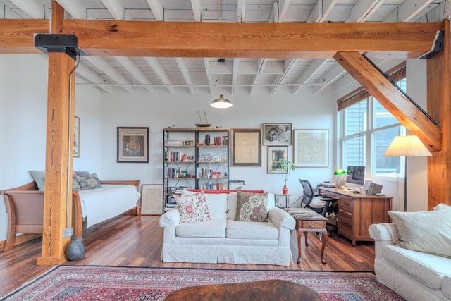 living area featuring beam ceiling and wood finished floors