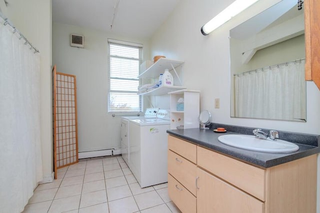 clothes washing area featuring a baseboard heating unit, light tile patterned flooring, visible vents, a sink, and washer and clothes dryer