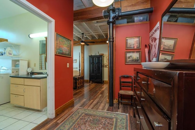 hallway with baseboards, beam ceiling, and wood finished floors