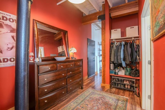 bedroom featuring a closet, beam ceiling, and wood finished floors