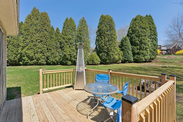 wooden deck featuring outdoor dining area and a yard