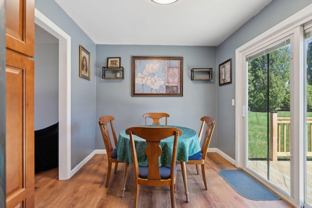 dining room with baseboards and light wood finished floors