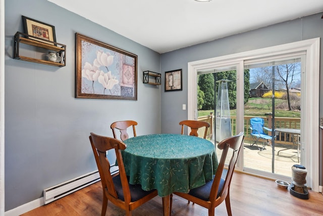 dining room featuring a baseboard radiator and wood finished floors