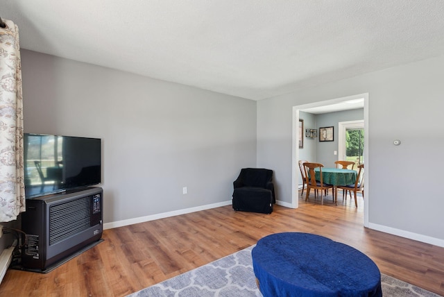 sitting room with baseboards and wood finished floors