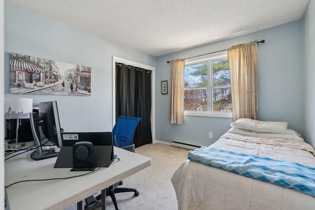 carpeted bedroom with a textured ceiling and a baseboard heating unit