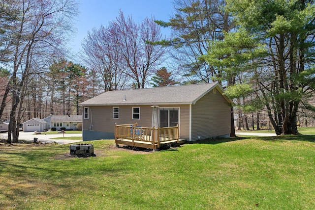 back of house featuring a lawn, an outdoor fire pit, and a deck