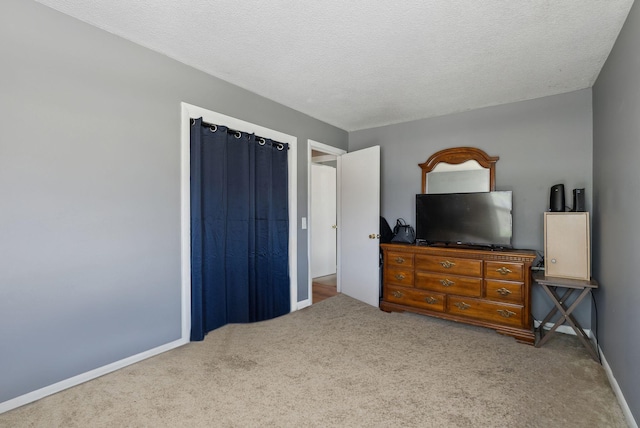 carpeted bedroom featuring a textured ceiling and baseboards