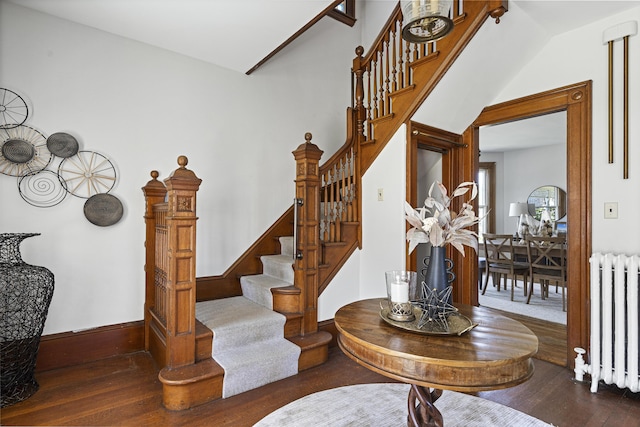 staircase with hardwood / wood-style flooring, baseboards, and radiator