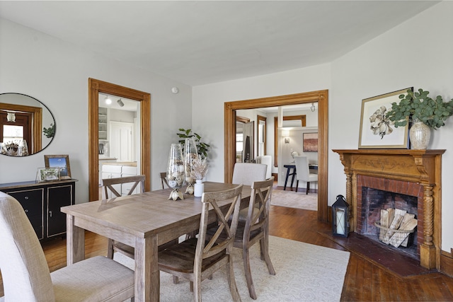 dining space featuring wood finished floors and a fireplace