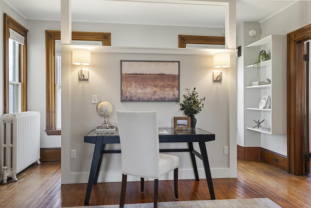 dining room featuring built in features, ornamental molding, radiator heating unit, and wood finished floors