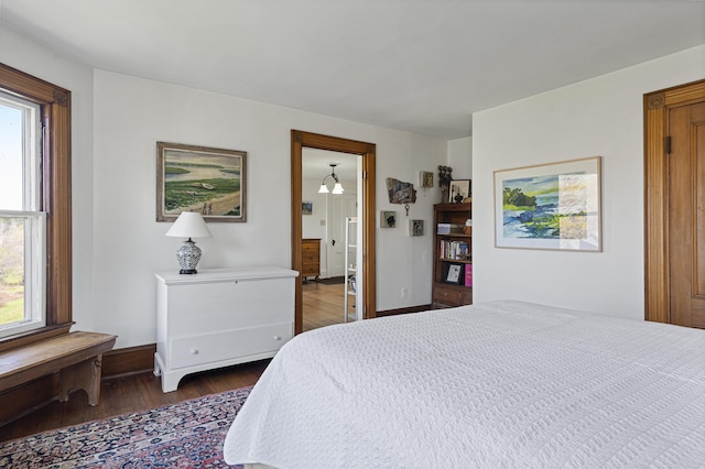 bedroom featuring baseboards and dark wood-style flooring