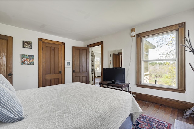 bedroom with wood-type flooring and baseboards