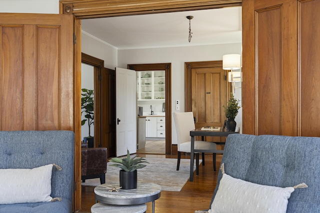 sitting room with crown molding and dark wood finished floors