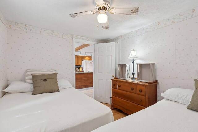30 Swan Cir, Shapleigh, ME 04076 - bedroom with wallpapered walls, freestanding refrigerator, light wood-type flooring, and ceiling fan