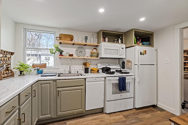 kitchen featuring wood finished floors, a sink, light countertops, gray cabinetry, and white appliances