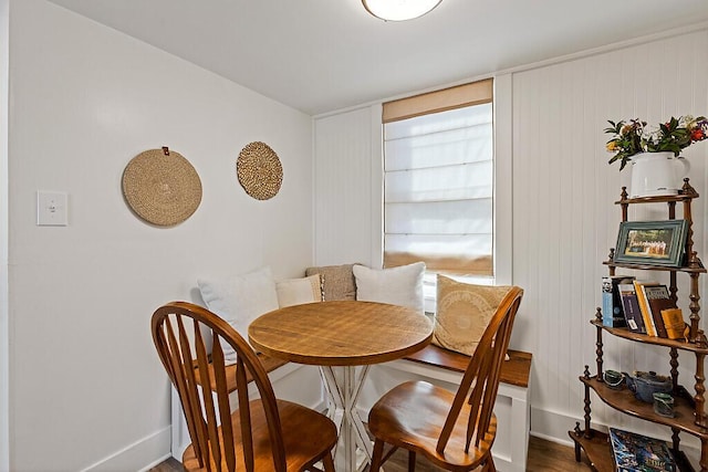 dining area with baseboards and wood finished floors