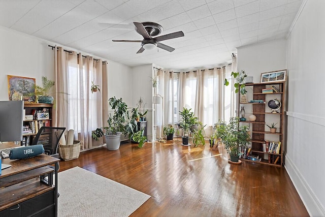 office area featuring baseboards, ornamental molding, a ceiling fan, and wood finished floors
