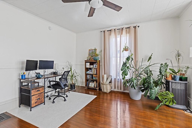 office area featuring a ceiling fan, visible vents, ornamental molding, and wood finished floors