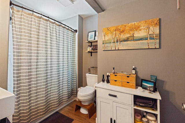full bath with toilet, wood finished floors, and a shower with shower curtain