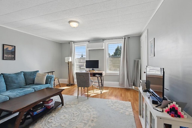 living area featuring baseboards, ornamental molding, and wood finished floors
