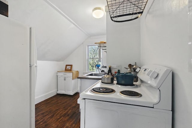 kitchen with a sink, white appliances, dark wood finished floors, baseboards, and lofted ceiling