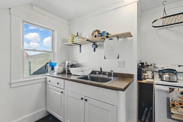 kitchen with open shelves, a sink, electric range, and dark countertops