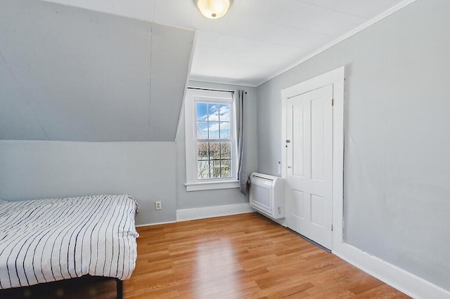 bedroom with baseboards, ornamental molding, and light wood-type flooring