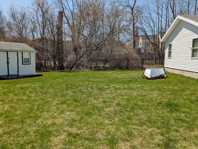 view of yard featuring a storage shed, an outdoor structure, and a fenced backyard