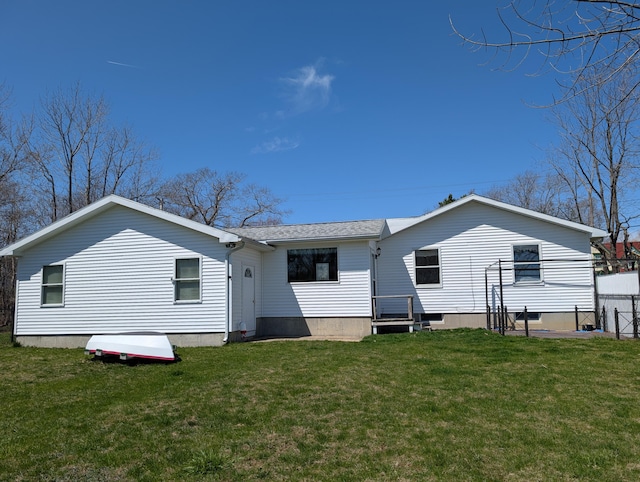 back of property featuring fence and a yard