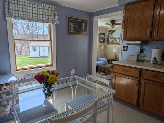 dining space with ornamental molding, light floors, and ceiling fan