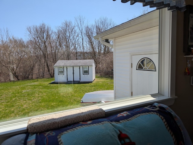 view of pool featuring a yard, fence, an outbuilding, and a storage unit