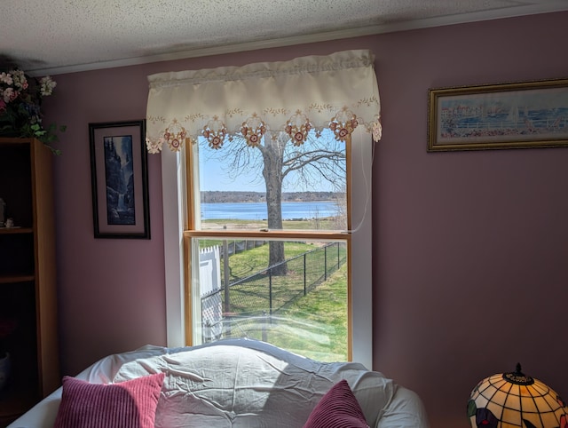 dining area featuring a water view and a textured ceiling