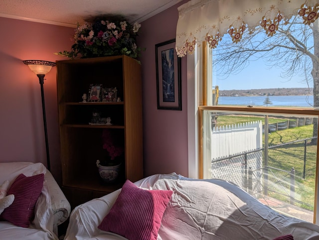 bedroom featuring a water view and ornamental molding