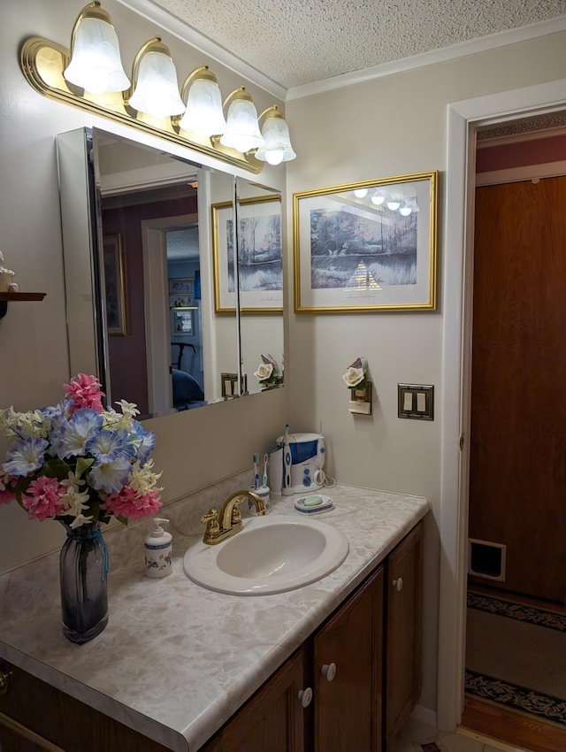 bathroom with crown molding, a textured ceiling, and vanity
